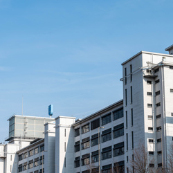 White industrial buildings against a clear blue sky